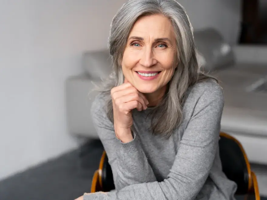 A smiling senior woman resting her chin on her hand