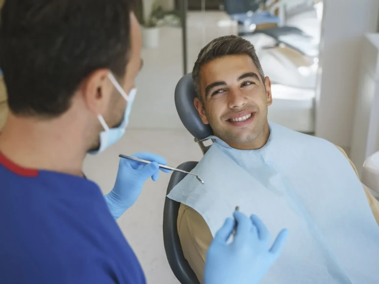 A male patient smiling and talking with his dentist during a visit