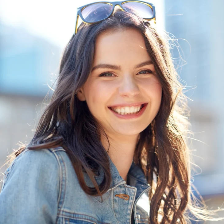 A smiling patient outdoors on a bright day
